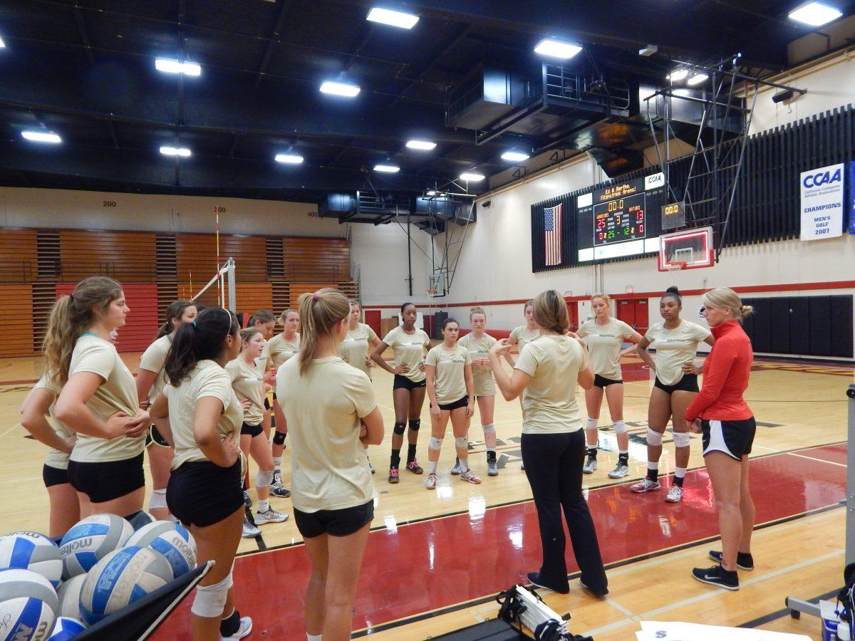 Head Coach Mallori Gibson-Rossi and Assistant Coach Chelsea Overholt talking to the volleyball team at practice.