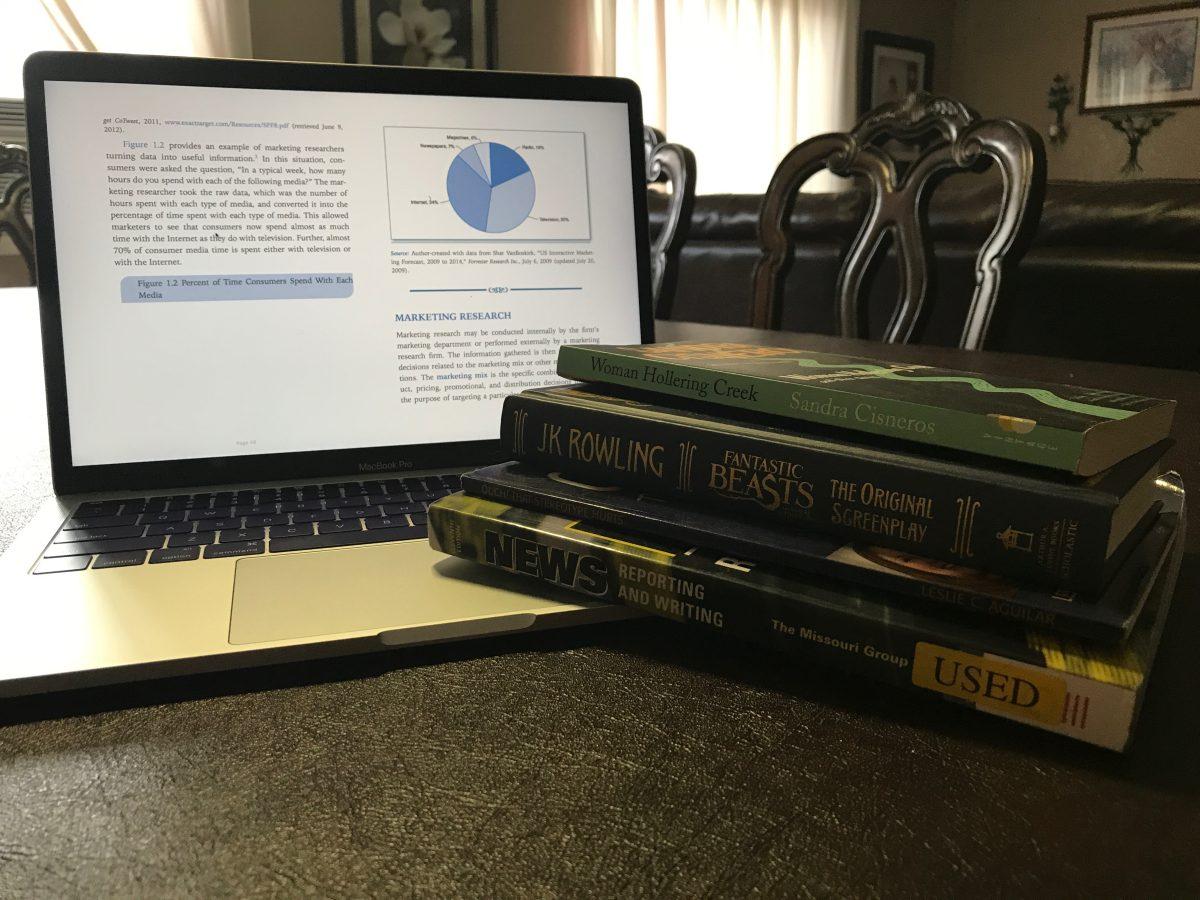 eBook on a laptop and a couple of physical books. (Signal photo/Vanessa Olmos)