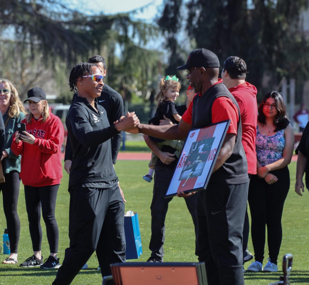 Jemar Armstrong receiving his senior photo frame from Coach Johnson.