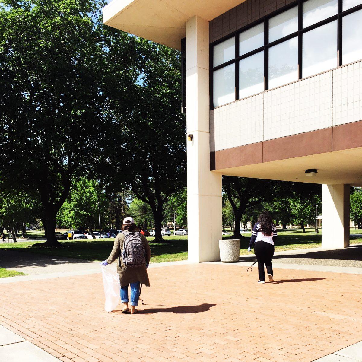 <p>Student volunteers, Ainee Elizarraras and Joseline Martinez, helping by picking up trash around campus. (Signal photo/Francely Santos)</p>