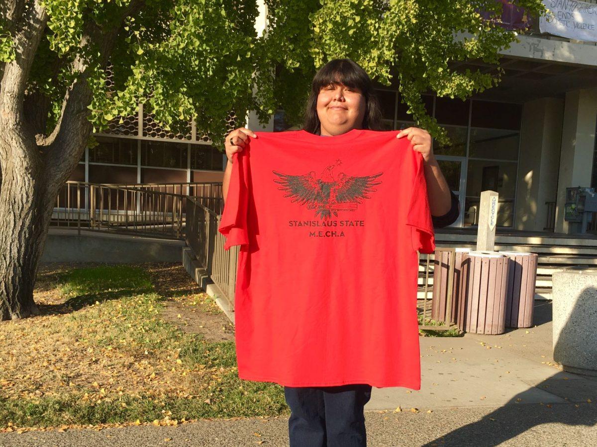 MEChA alumni, Gloria Vallin (senior, Communication Studies) showing the new MEChA t-shirts that members will be wearing during the march. (Signal photo/ Francely Santos)