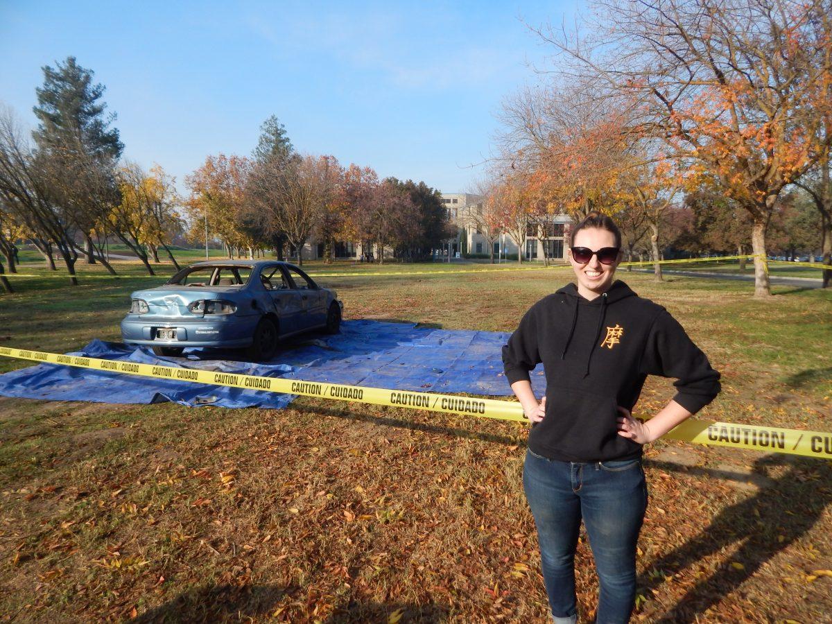 Madeline Runyan next to the car that was being used to let out students' stress. (Signal Photo/Jesus Valdez).