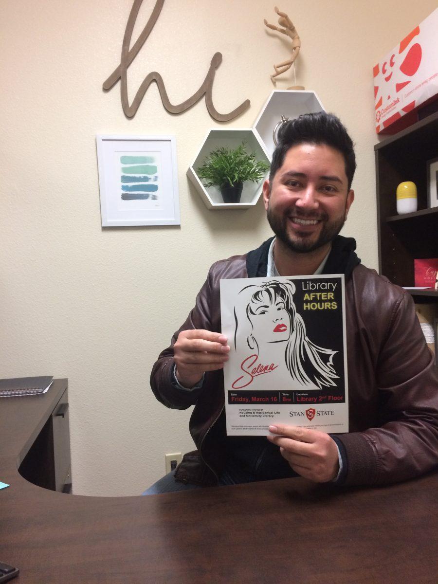 Miguel Pulido, Communications Specialist for Housing, displays the Selena movie night flyer. (Signal Photo/Emily Hake)