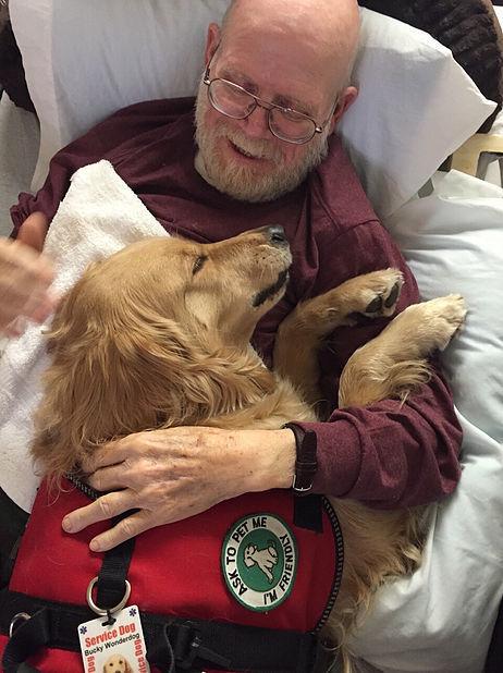 Bucky cuddling with patient Tom. (Photo courtesy of David Ebel)