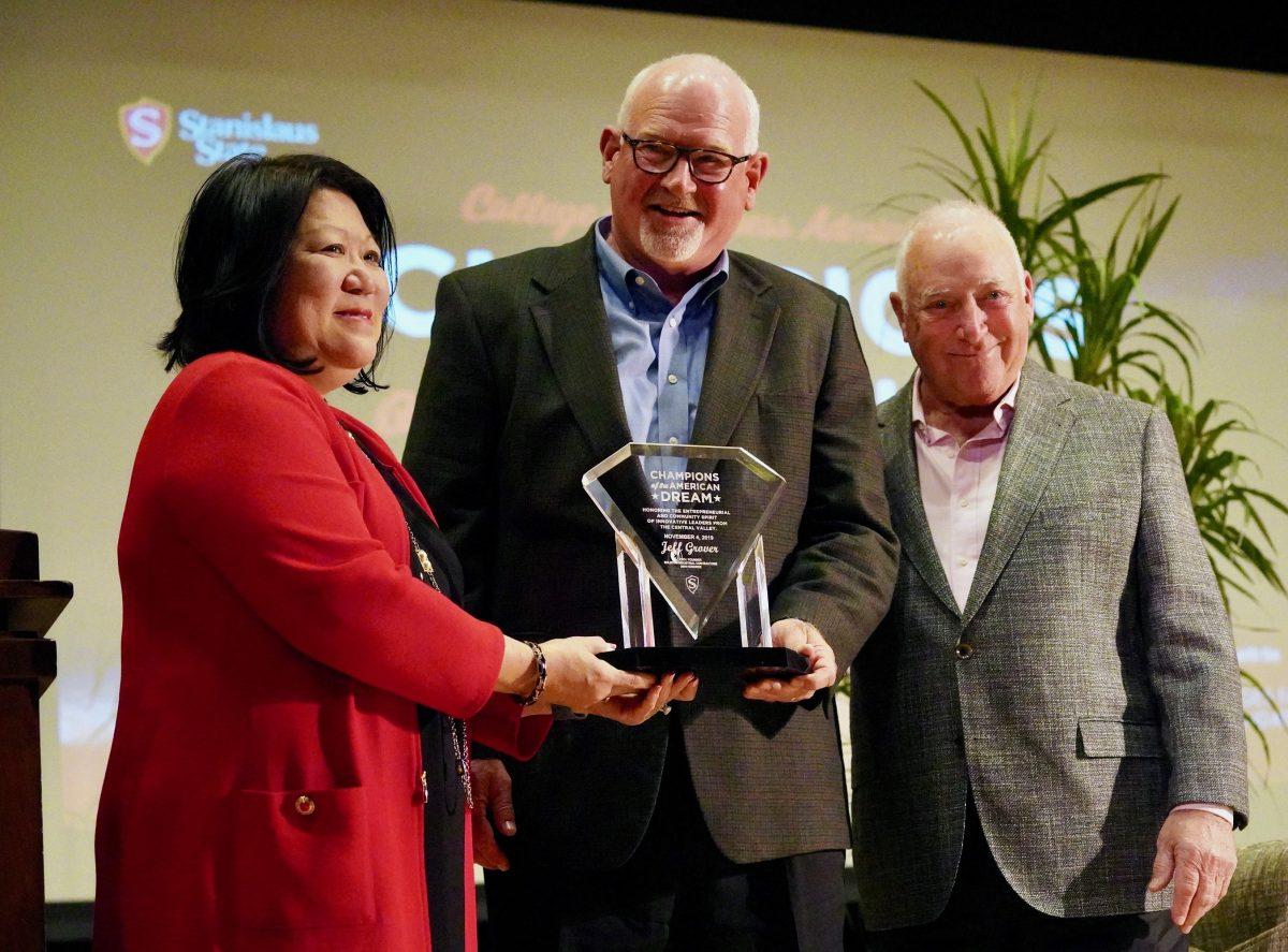 Stan State President Ellen Junn presents an glass plaque to CEO Jeff Grover (Signal Photo/ Randel Montenegro)