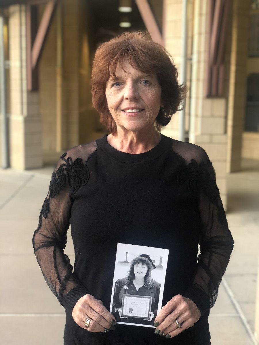 Carol Cabral standing with a photo of herself when she graduated from Stan State. (Signal&#160;Photo/ Danielle Castillo).