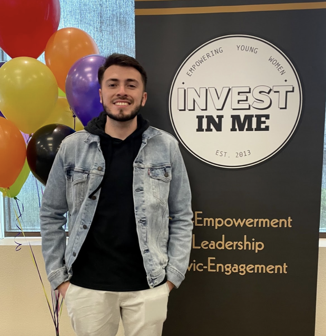 Robert Rodriguez, a panelist speaker stands in front of the Invest In Me sign, smiling proudly and humbly honored to have attended. (Photo courtesy of Robert Rodriguez)