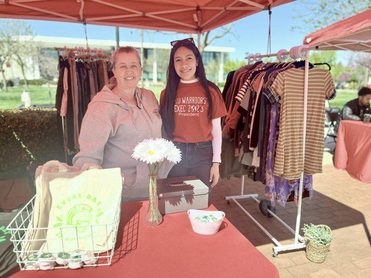 Eco Warriors Club president, Anahi Lopez (third year, Business Administration) and fellow club member, Bonnie Arbuckle (senior, Liberal Studies) posing together in Clothing Swap booth at Warrior Wednesday 