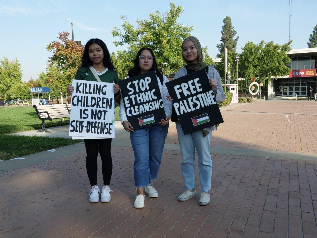 Samiya Sanguilan (Freshmen, Pre-Nursing) on the left, Itzel Velis (Senior, Mathematics) in the middle, and Saifa Sanguilan (Senior, Public Health) on the right, standing together and holding up their protest protesters. (Signal Photo/Veronica Sexton)