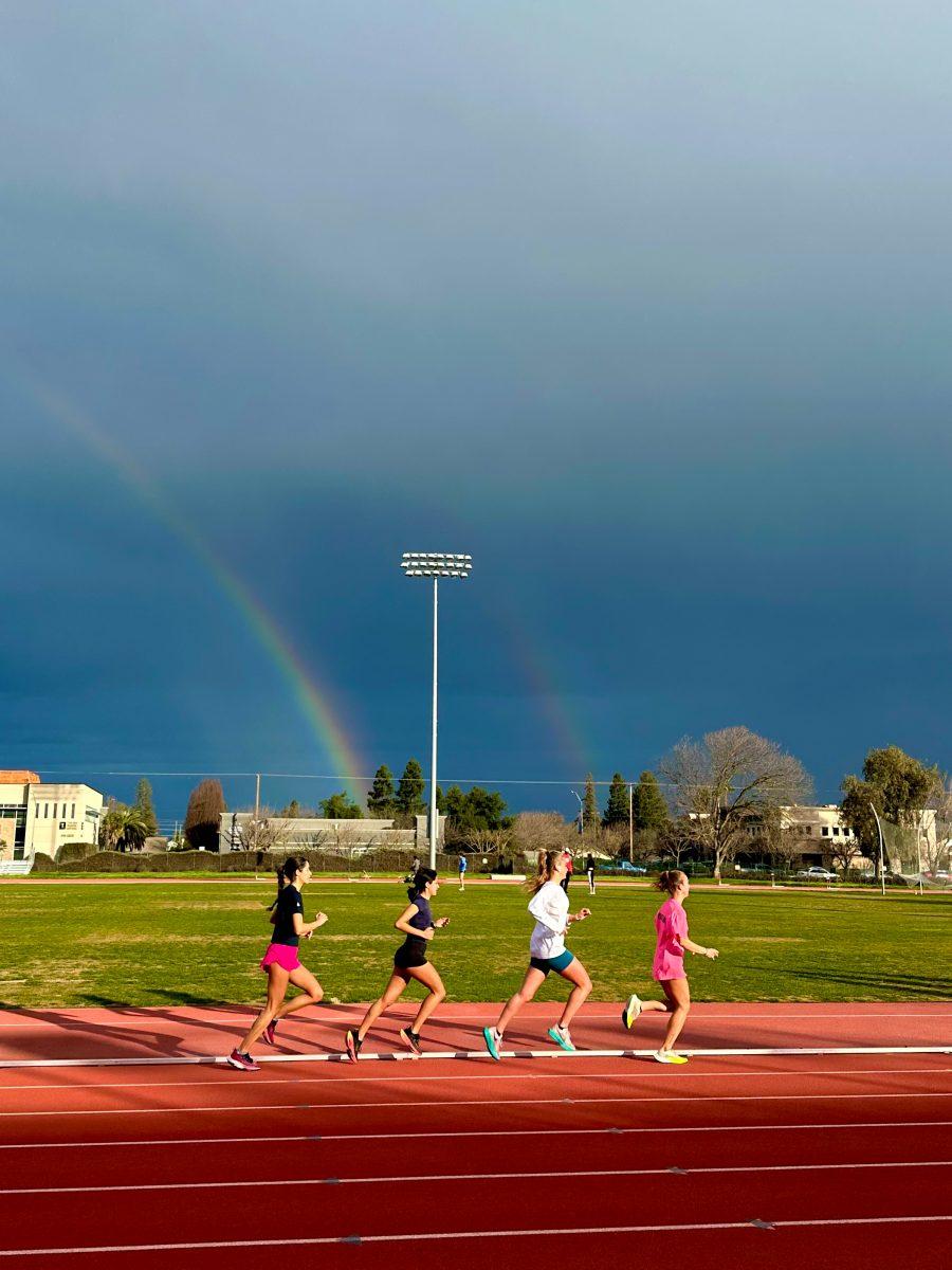A group of runners running the Al Brenda Track in the aftermath of the storm. The sky is still cloudy and there is a rainbow behind them. (Signal Photo/Isabel Arrizano)