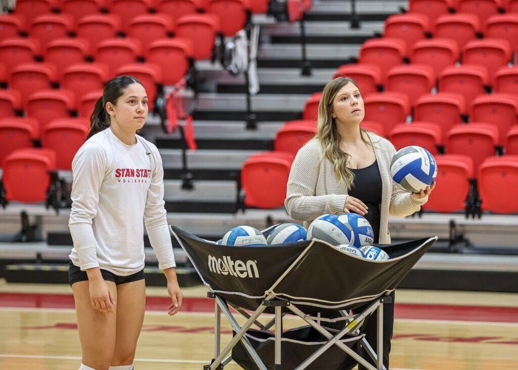 Maggie Billinglsey (right) assisting in game time warm up. (Photo courtesy of JKettering Photography)
