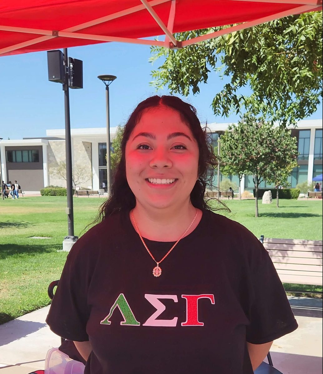 Jasmine Hernandez Delgads (Junior, Exercise Science) standing at the Lambda Sigma Gamma booth as they table in the quad. 