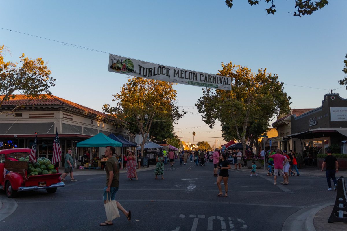 The intersection of Main Street during the Turlock Melon Carnival filled with vendors and attendees.