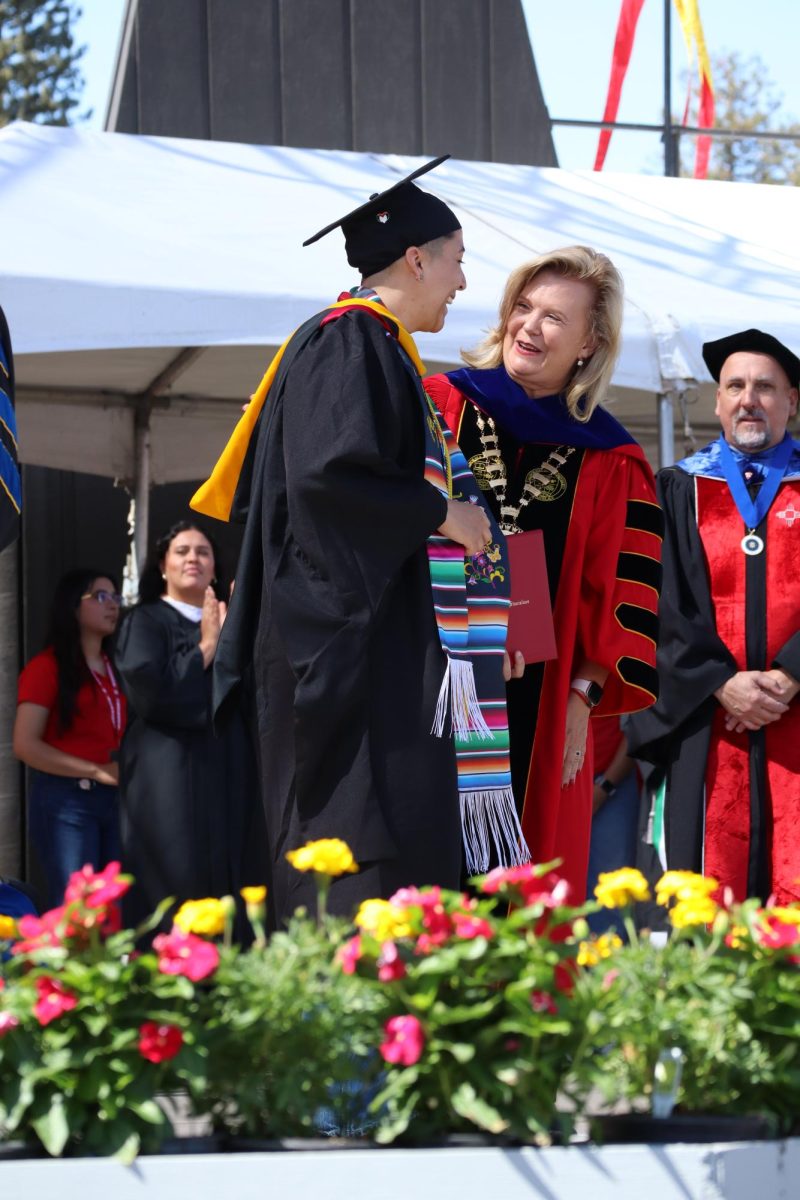 President Britt Rios-Ellis congratulating College of Science graduate
