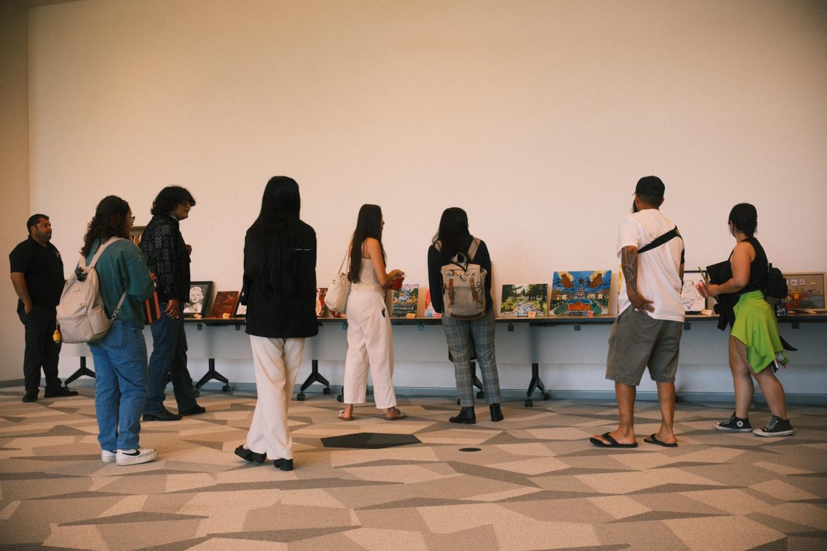 Attendees browse art pieces displayed at the Student-Centered Art Showcase. 
