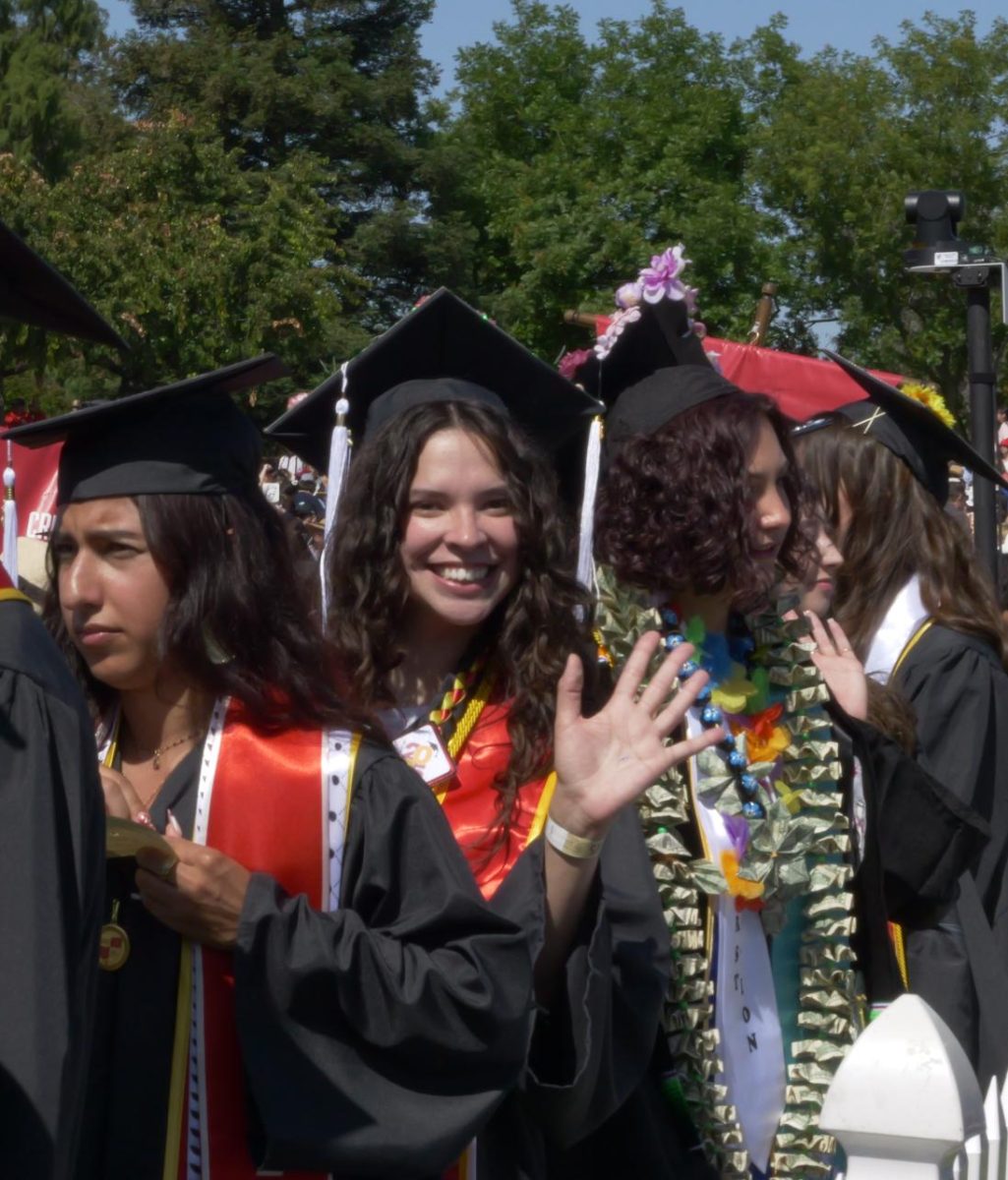 Malina Duran waving, receiving her B.A. in Creative Media.