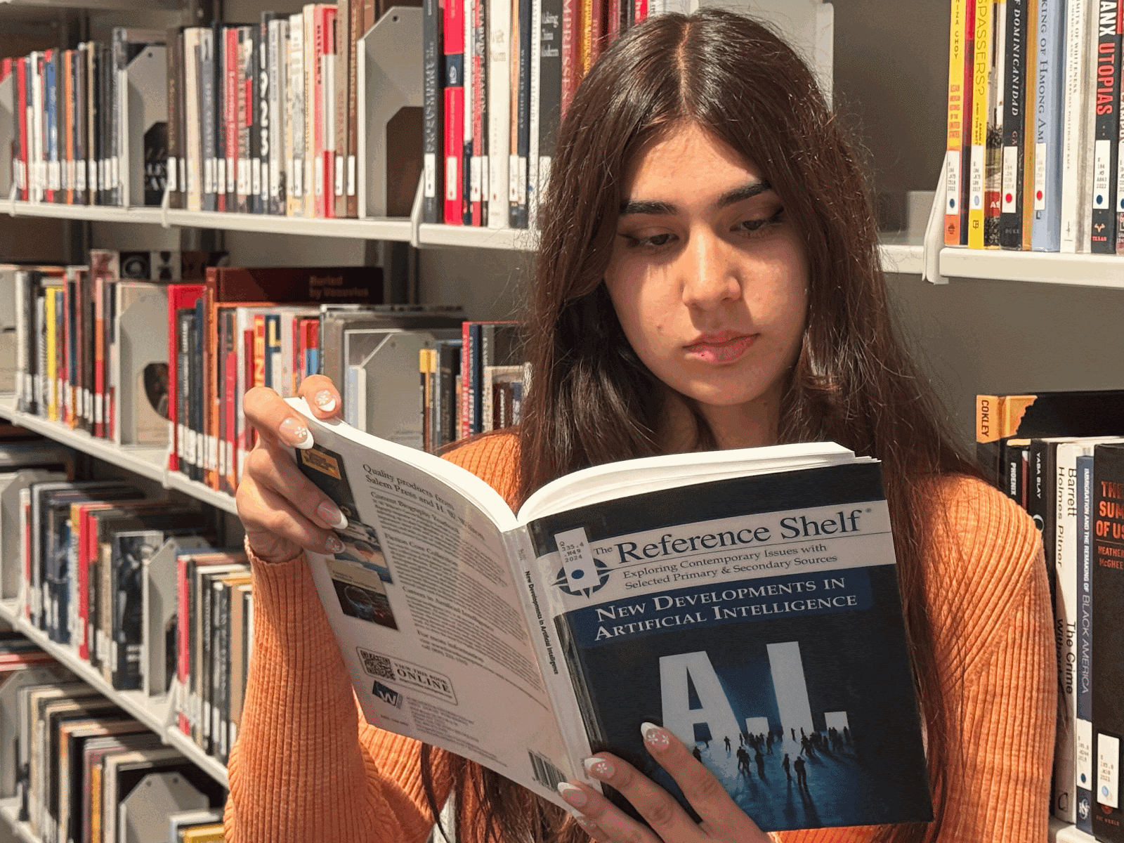 Emaan Nawabi (Freshman, Communications) is reading a book on the developments of AI to learn more