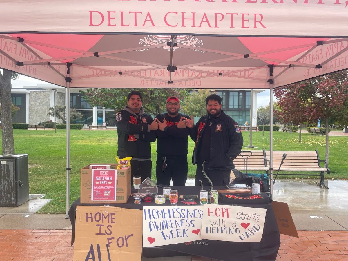 Picture of three members of Nu Alpha Kaapa (NAK) raising awareness for homelessness and accepting donations
