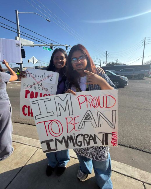 Left to Right Shriya Sharma (Senior, Gregori Highschool) and Deetya Thogarucheeti (Junior, Gregori High School) hold up signs on Dale Road. (Photo provided by Hadia Rasouli)