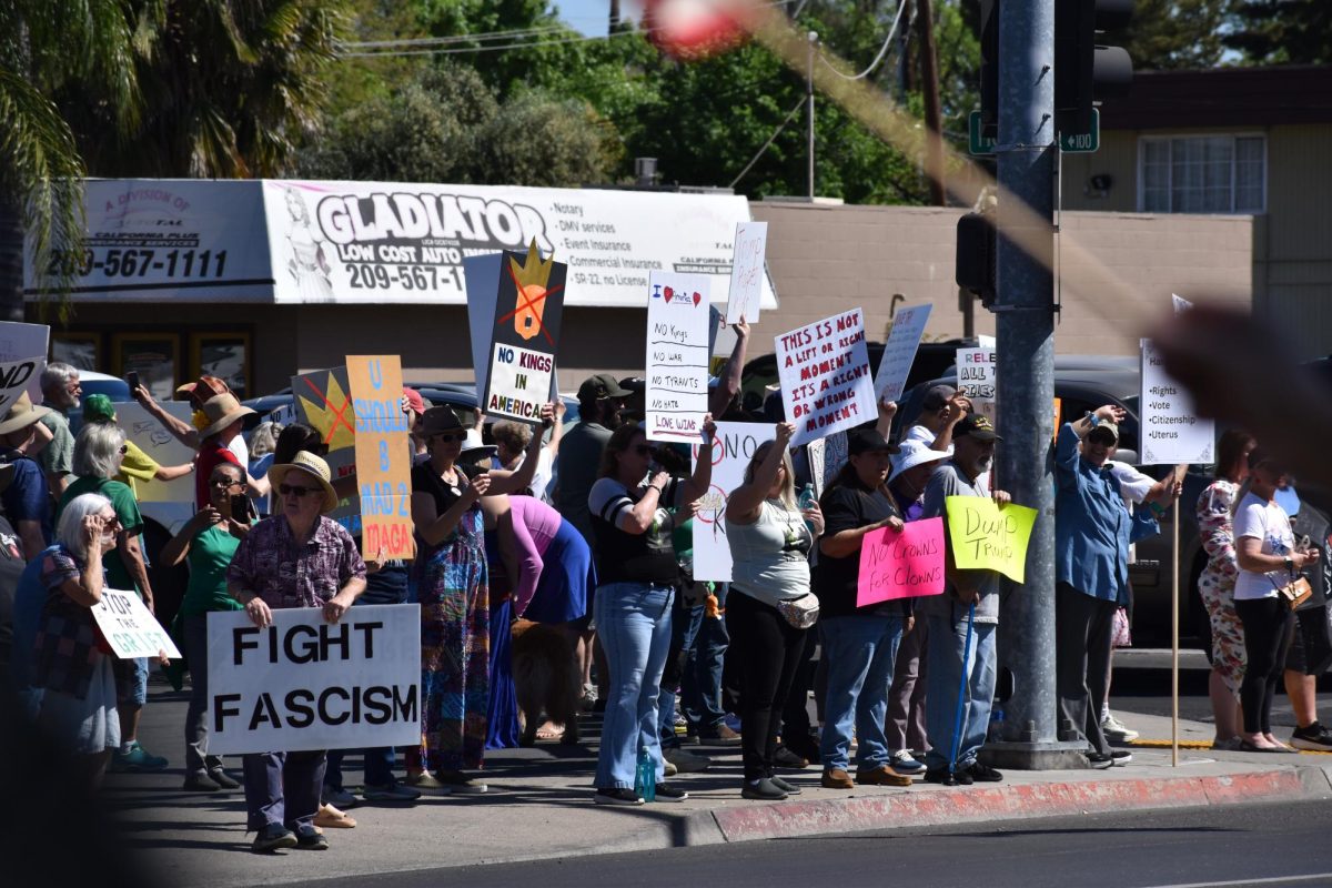 Protestors stand on 5 points and hold up their signs for traffic to see on Saturday, March 28,  2026 at the No Kings Protest in Modesto.