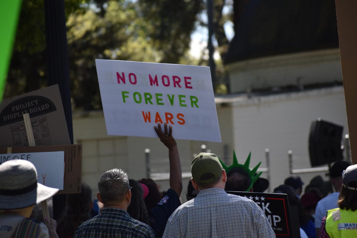 Protestor holds up a sign that reads, "No more forever wars," on Saturday, March 28,  2026 at the No Kings Protest in Modesto.