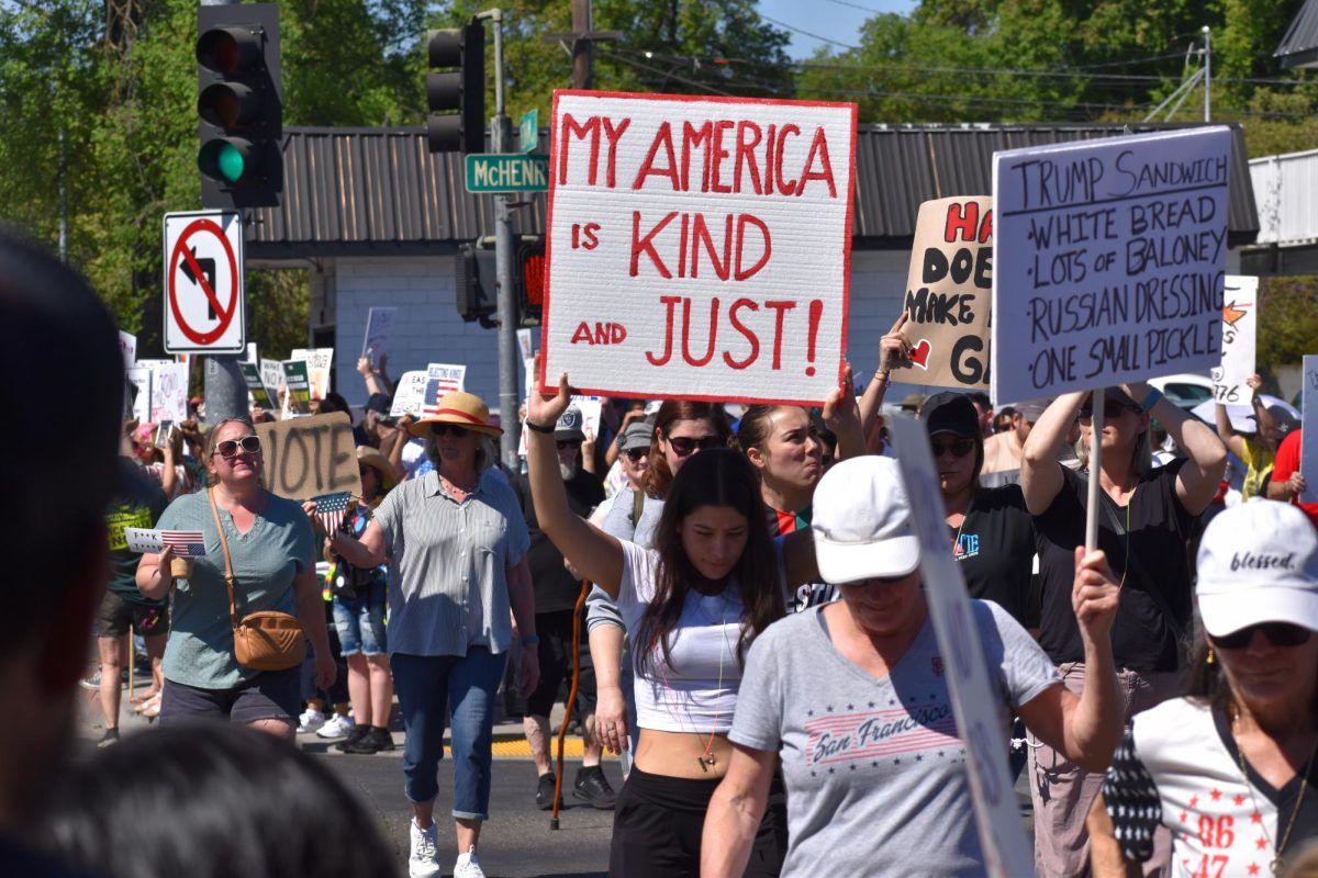 Protestors cross the street on Mchenry at 5 points on Saturday, March 28,  2026 at the No Kings Protest in Modesto.