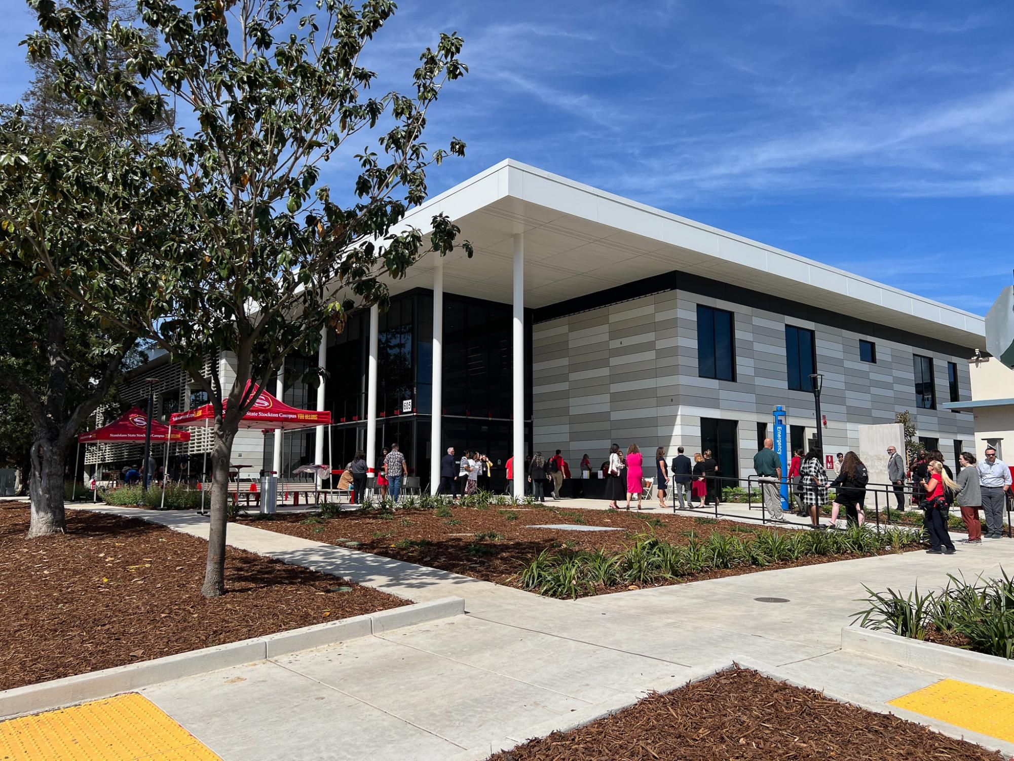 An outside view of the new Willow Hall with guests and staff waiting outside for the event on March 26, 2026, at the Stan State Stockton Campus.