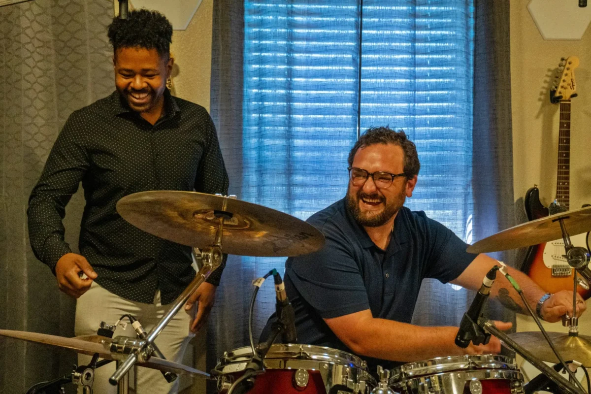 Modesto Sound Executive Director Mitchell Dill (right) sets up the drums as Board President Brandon Jamal stands behind him, at the nonprofit's studio. Credit: Teisy Zavala-Cortez / The Modesto Focus